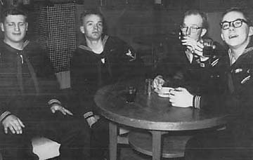 four sailors sitting at cocktail table